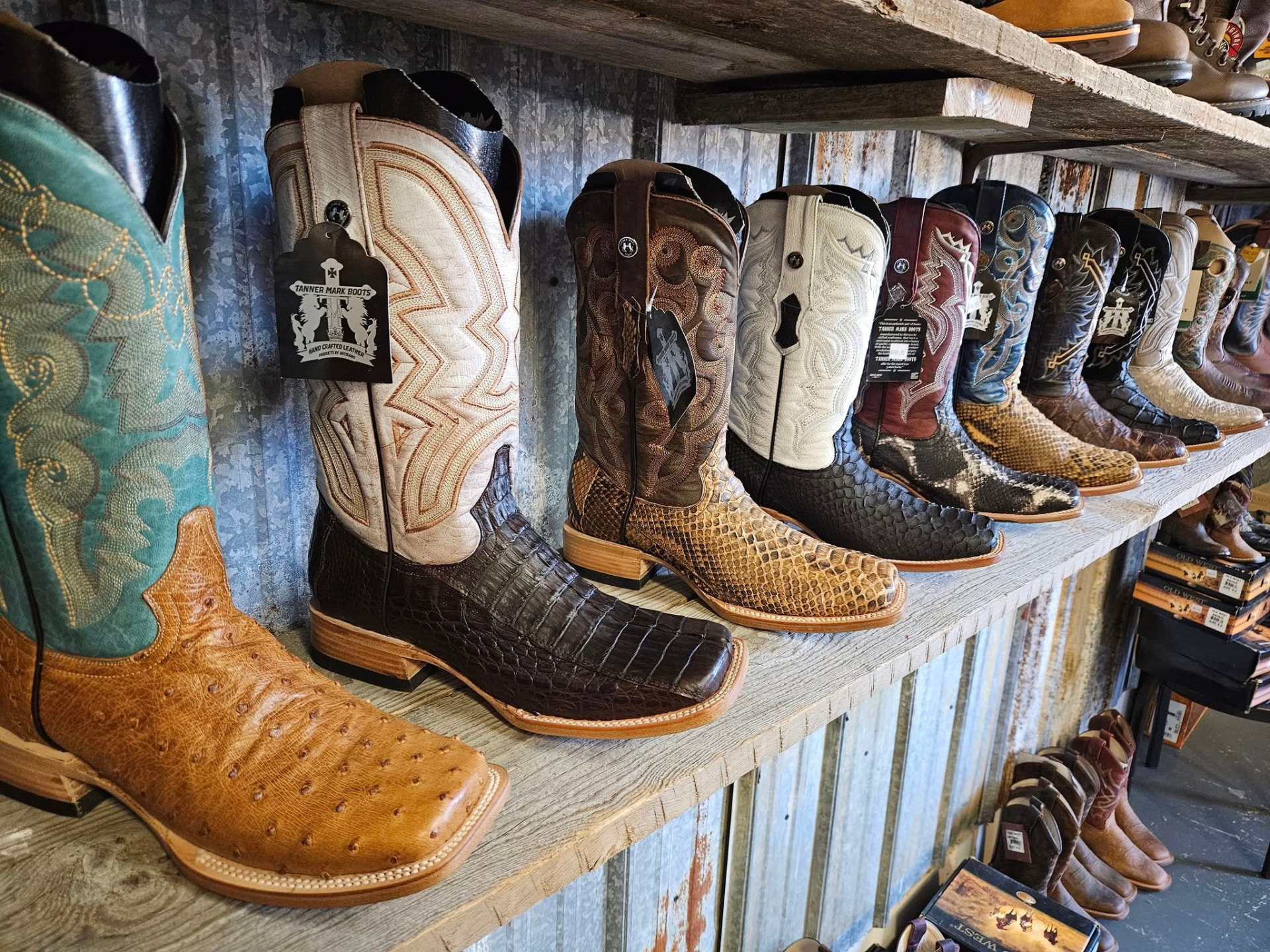 Ostrich, caiman and python cowboy boots lined along the tin-walled shelf