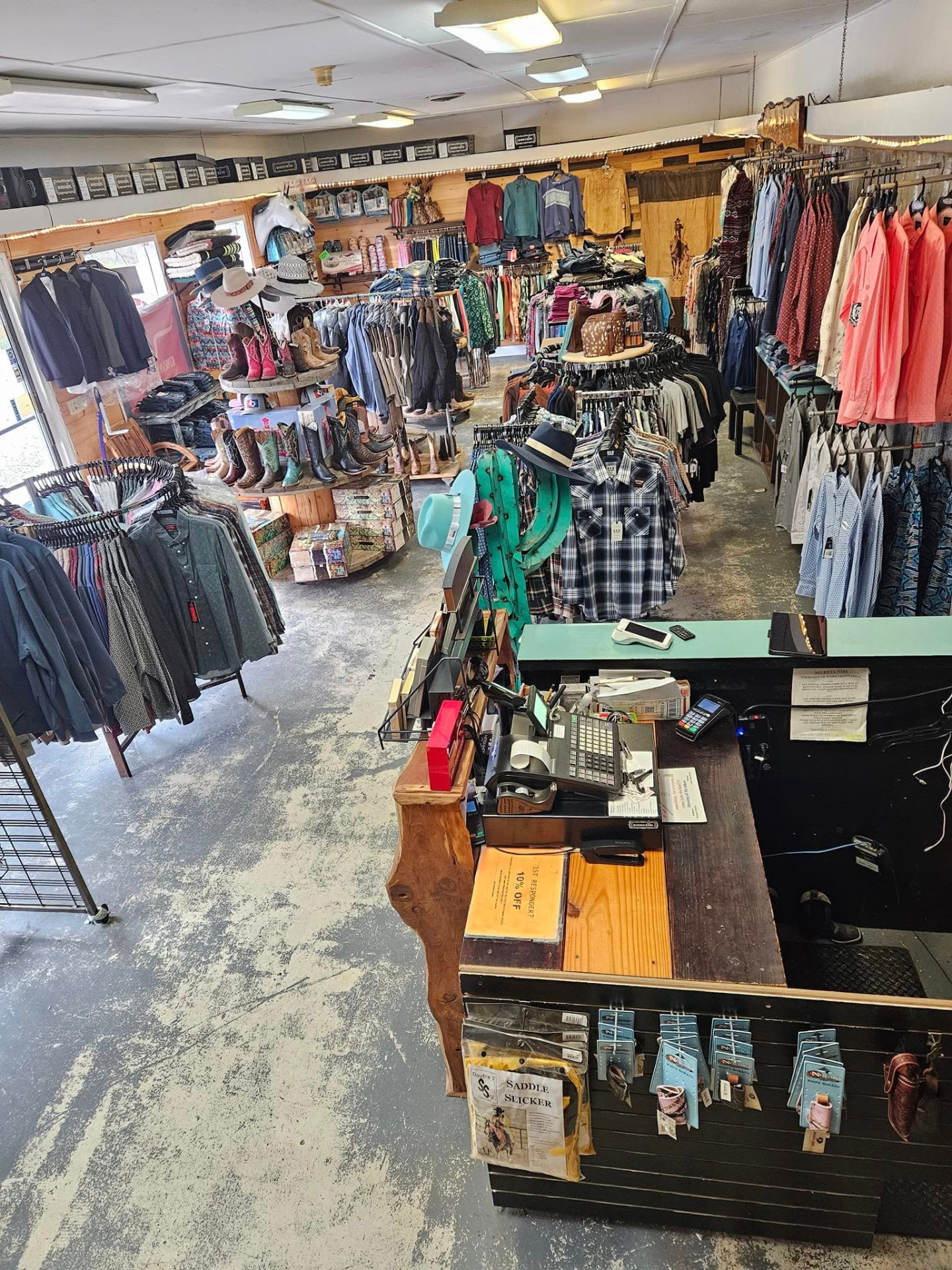 Rows of cowboy boots and straw hats on the tin-walled shelves inside Take the Reins